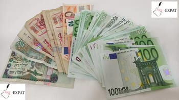 Billets en euros de différentes valeurs, dispersés sur une surface blanche.