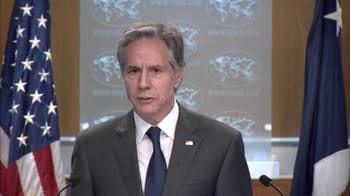 Homme en costume lors d'une conférence de presse officielle.
