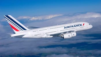 Avion Air France survolant les nuages dans le ciel bleu.