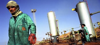 Ouvrier dans une usine pétrolière en Algérie avec équipements industriels.