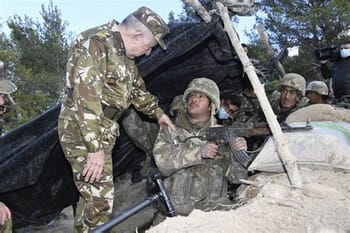 Soldats en uniforme dans une zone de combat avec un officier.
