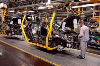 Ligne de production automobile au Maroc, avec un technicien inspectant une voiture en assemblage.