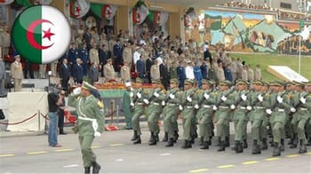Soldats algériens en parade militaire avec drapeau national.