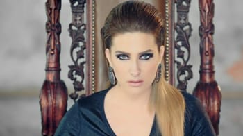Kenza Morsli avec maquillage sophistiqué et coiffure élégante.