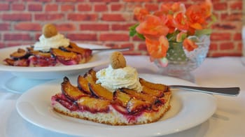 Part de gâteau aux fruits avec crème et amandes, prêt à être servi.