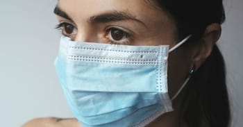 Femme portant un masque facial bleu pour la protection contre la COVID-19.