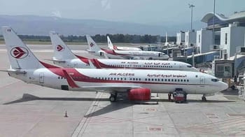 Avions Air Algérie stationnés à l'aéroport avec terminal moderne en arrière-plan.