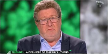 Homme en interview avec lunettes et expression sérieuse.