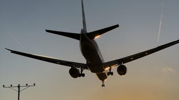 Avion en approche pour atterrir à l'aéroport au coucher du soleil.