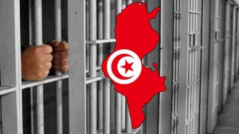 Prison en Tunisie avec des mains derrière les barreaux.