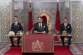 Rencontre officielle au Maroc avec drapeaux marocains et décor traditionnel.