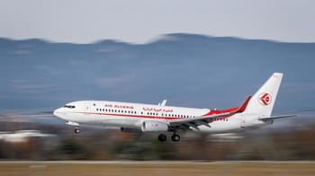 Avion d'Air Algérie en vol au-dessus du paysage montagneux.