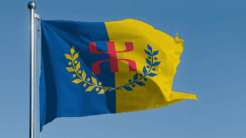 Drapeau kabyle flottant dans le ciel bleu.