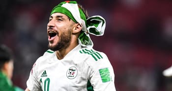 Footballeur algérien avec bandana vert et blanc, célébrant sur le terrain.