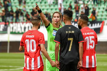 Arbitre féminine en action lors d'un match de football au Maroc.