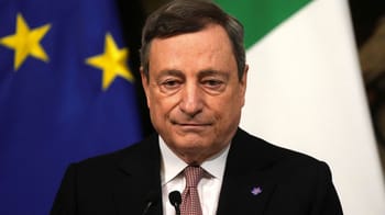 Mario Draghi en costume noir avec drapeaux de l'UE et de l'Italie en arrière-plan.