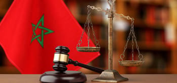 Balance de la justice avec drapeau marocain en arrière-plan.