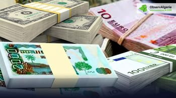 Billets de banque en dollars et euros empilés sur une table.