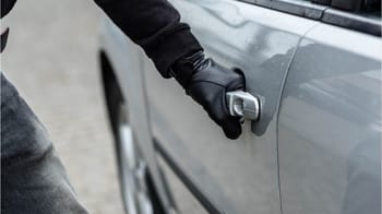 Personne utilisant une clé pour ouvrir une voiture en plein air.