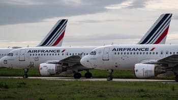 Deux avions Air France alignés sur le tarmac sous un ciel nuageux.
