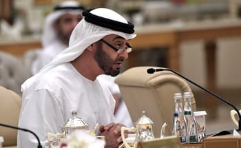 Mohammed ben Zayed en réunion, portant une robe traditionnelle et des lunettes.