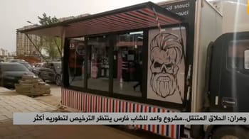 Jeune coiffeur ambulant avec un camion de coiffure mobile en Algérie.