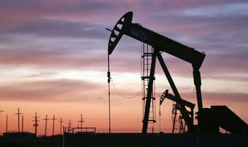 Puits de pétrole en activité au coucher du soleil.