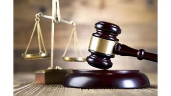 Balance de la justice et marteau de juge sur un fond en bois.
