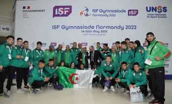 Groupe d'athlètes algériens avec drapeau à la Gymnasiade 2022.