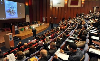 Audience lors d'une conférence sur la collecte des dossiers pour postes de professeurs assistants.