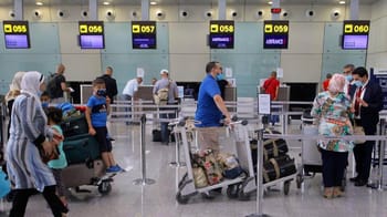 Passagers à l'aéroport en Algérie avec valises et contrôles de sécurité.