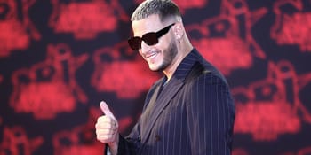 DJ Snake portant des lunettes de soleil, souriant lors d'un concert.