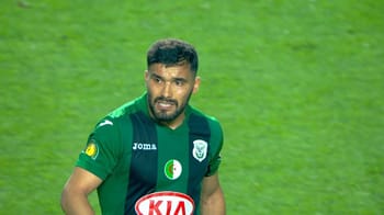 Footballeur en vert lors d'un match, expulsé pour un tir immoral.