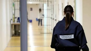 Agent pénitentiaire dans un couloir de prison en France.