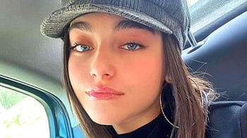 Jeune femme portant une casquette dans une voiture, regardant l'objectif.