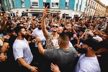 DJ Snake entouré de fans lors d'un événement musical en ville.