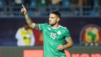 Andy Delors en maillot vert, pointant du doigt sur le terrain.