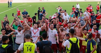 Joueurs de football célébrant leur victoire sur le terrain.