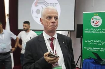 Homme sérieux en costume lors d'une réunion FIFA en Algérie.