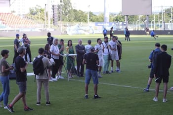 Spectateurs et joueurs sur le terrain lors d'un match de football.