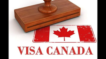 Sceau de visa sur une table en bois avec drapeau canadien.