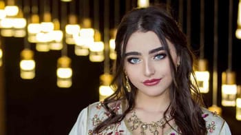 Jeune femme avec maquillage sophistiqué et bijoux élégants.