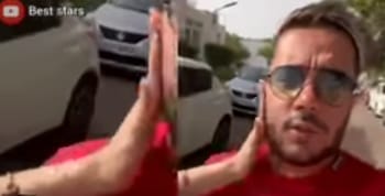 Mohamed Benchenet en selfie, en extérieur, avec des voitures en arrière-plan.