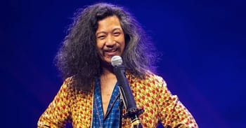 Bun Hay Mean avec cheveux bouclés et sourire, parlant dans un micro.