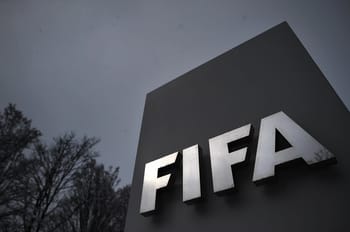 Logo de la FIFA sur un panneau en extérieur, ciel nuageux.