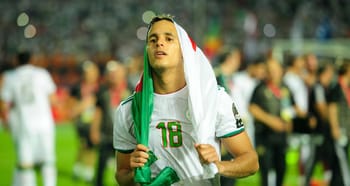 Zeffane avec le drapeau algérien lors d'un match de football.
