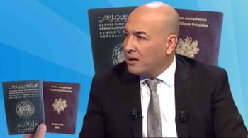 Député Chaabna parle lors d'une interview avec documents officiels en arrière-plan.