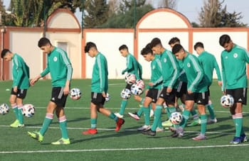 Jeunes joueurs de football algériens s'entraînent sur le terrain.