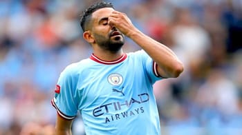 Riyad Mahrez avec le maillot de Manchester City, visage frustré.