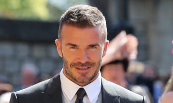 David Beckham en costume lors d'un événement public en plein air.